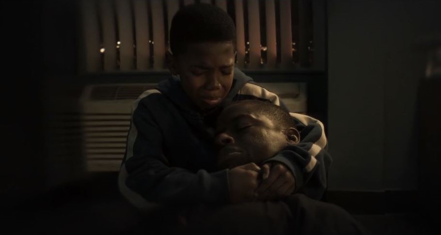 A young Erik Killmonger hugging the dead body of his father